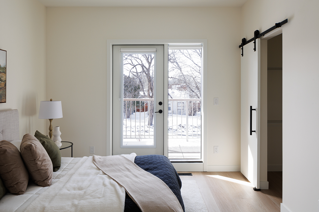 Sunlit bedroom with french doors to the balcony