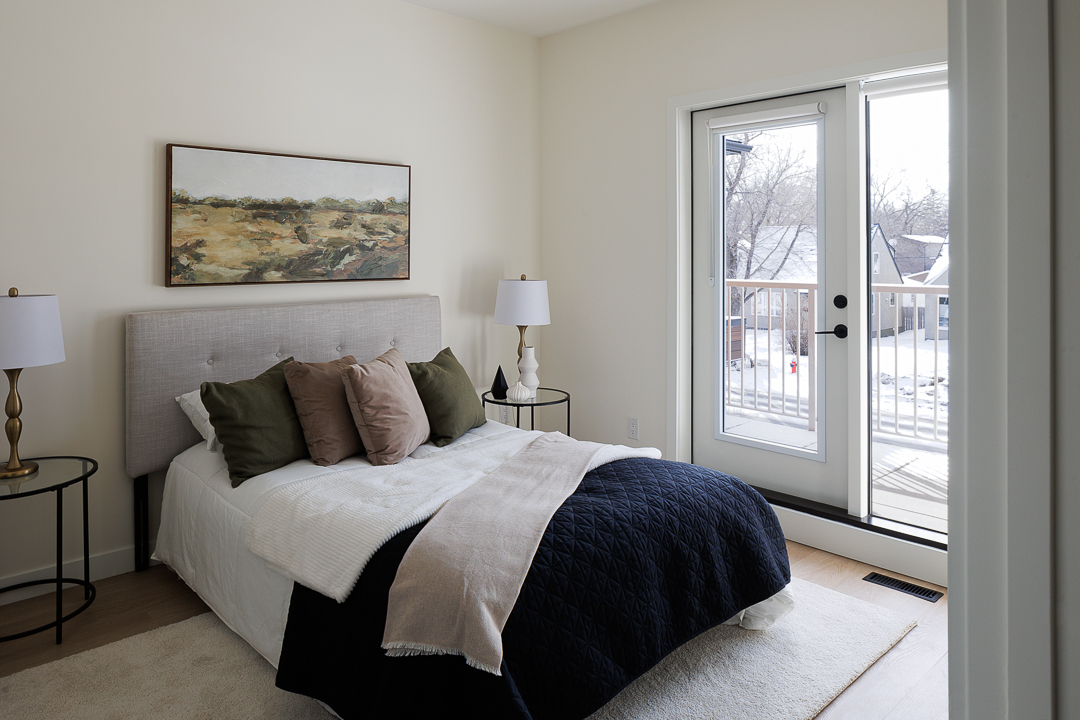 Bedroom with upholstered bed and balcony access